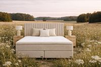 Swedish boxspring bed in natural beige placed in an open field, highlighting comfort, quality materials and Scandinavian design